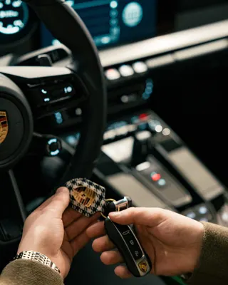 Porschen avain kädessä auton sisällä