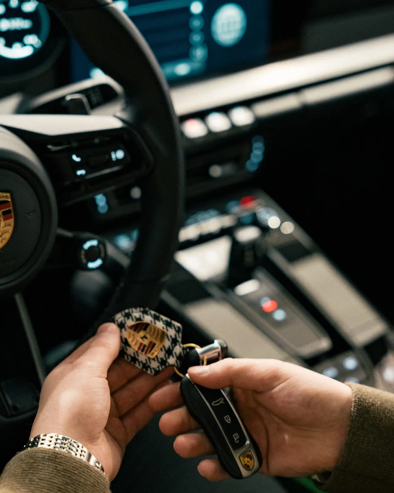 Porschen avain kädessä auton sisällä