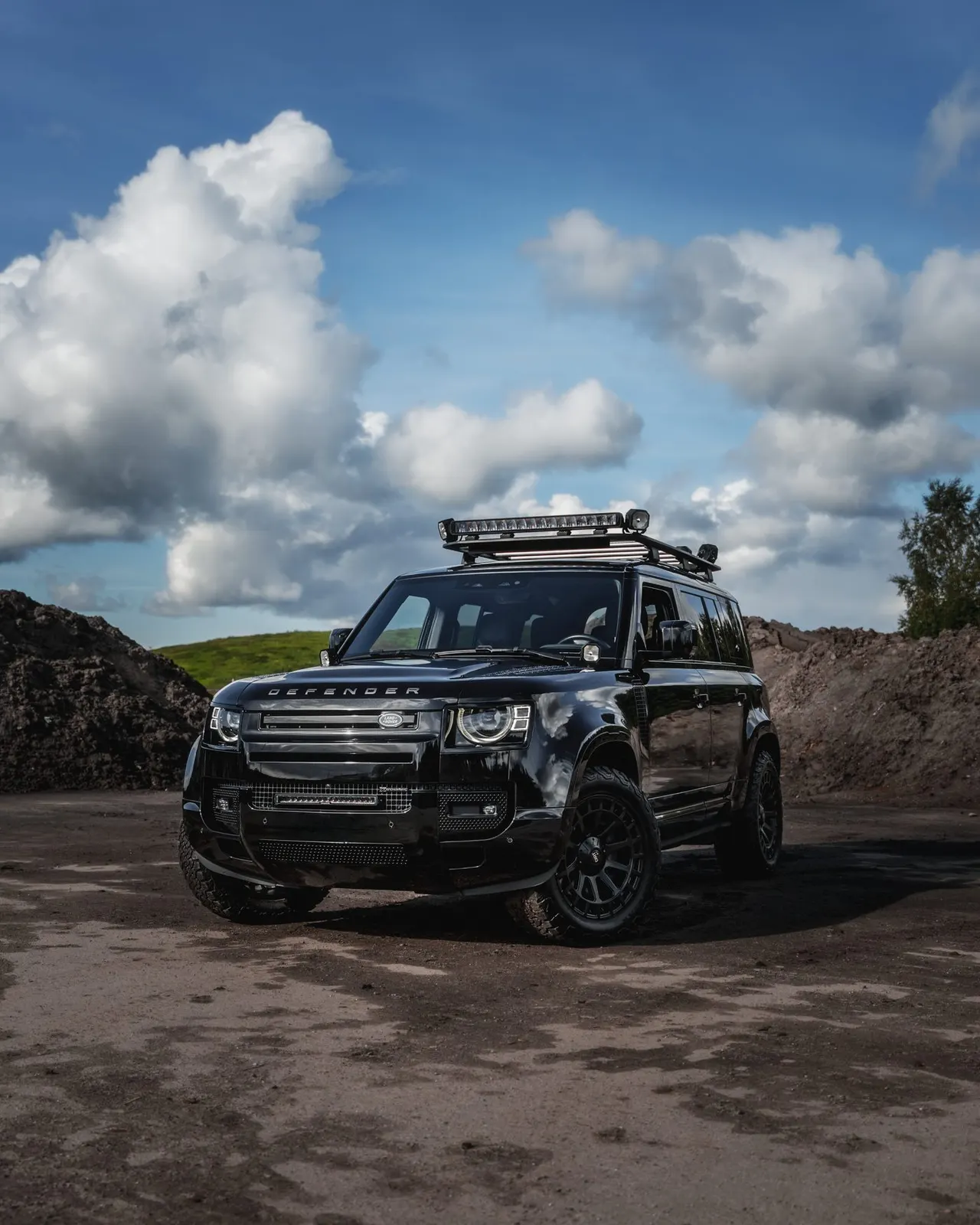 Land Rover Defender soratiellä dramaattisen pilvitaivaan alla